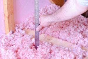 Measuring the thickness of fiberglass insulation in the attic