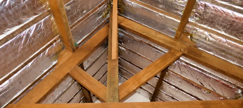 aluminum foil roof insulation exposed in a vaulted ceiling after wood panel removed