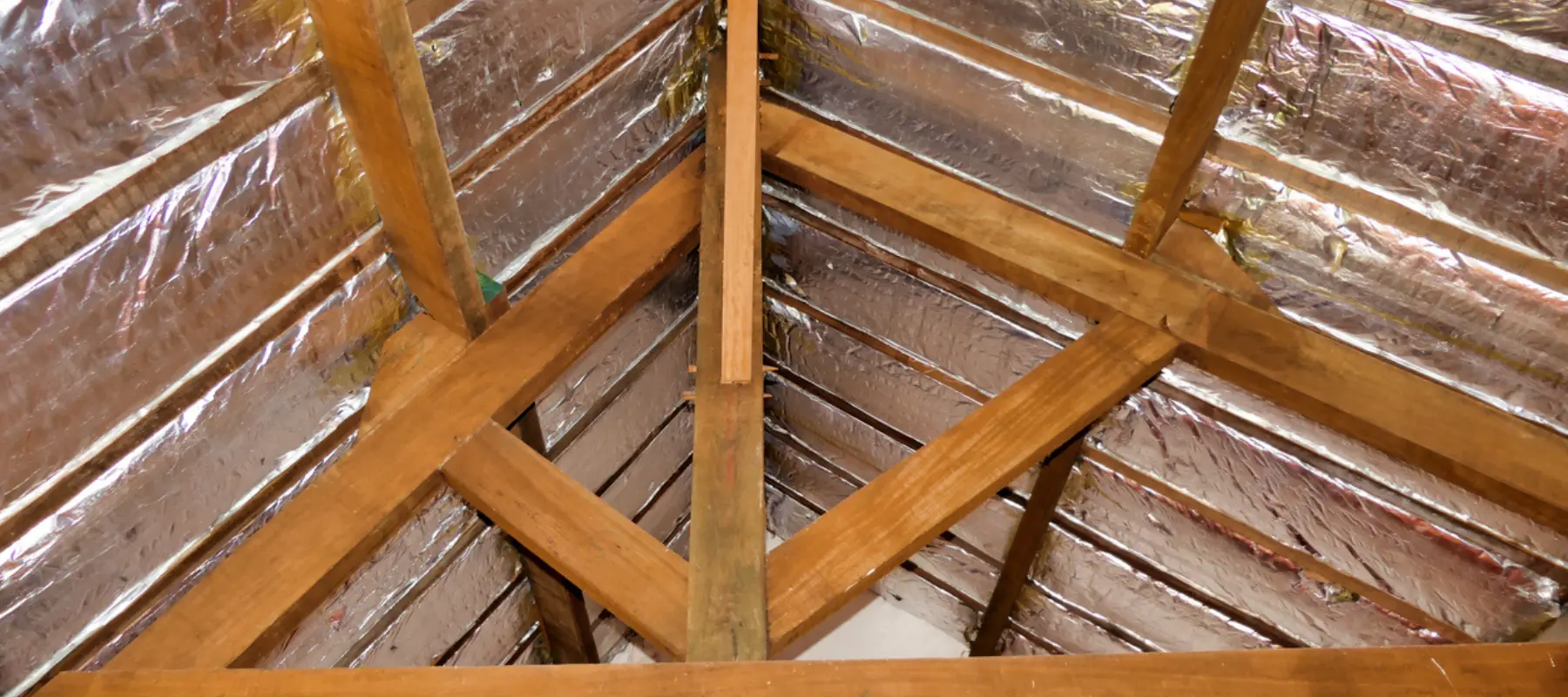 aluminum foil roof insulation exposed in a vaulted ceiling after wood panel removed